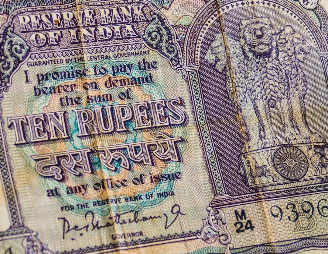 A currency exchange board showing USD and INR values, with the INR value highlighted as depreciating. There are arrows indicating money moving out of India.